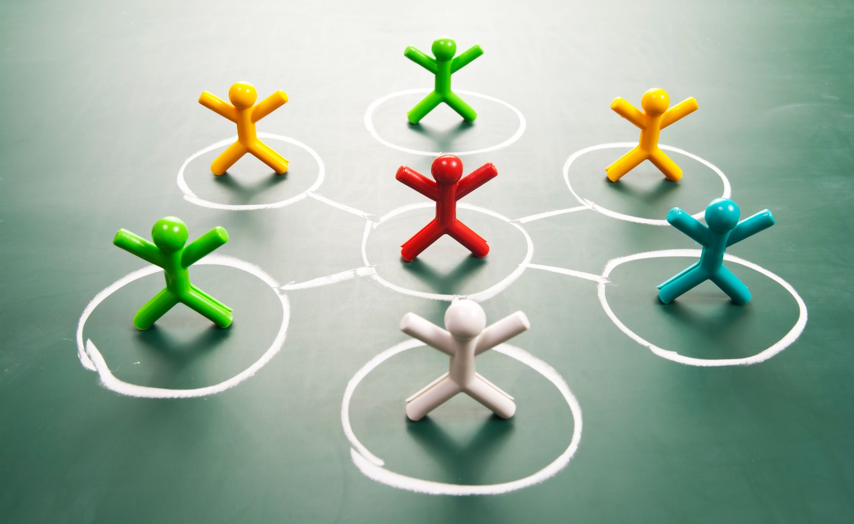 Teamwork concept. Colourful dolls on blackboard.